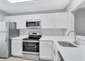 Thumbnail 1 of 25 - a kitchen with white cabinets and stainless steel appliances