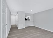 Thumbnail 23 of 25 - a renovated living room and hallway with white walls and wood floors
