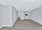 Thumbnail 24 of 25 - a renovated living room and hallway with white walls and wood floors