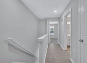 Thumbnail 25 of 25 - a white hallway with stairs and a door to a bathroom