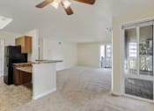 Thumbnail 2 of 23 - an empty living room and kitchen with a door to a balcony