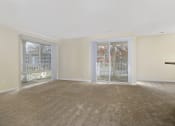 Thumbnail 4 of 23 - an empty living room with sliding glass doors to a balcony