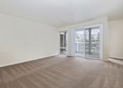 Thumbnail 14 of 23 - an empty living room with a sliding glass door to a balcony