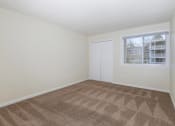 Thumbnail 8 of 23 - an empty living room with carpet and a window