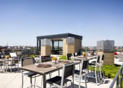 Thumbnail 44 of 50 - a rooftop terrace with tables and chairs and a view of the city