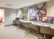 Thumbnail 43 of 50 - a conference room with four computer desks and a mural on the wall