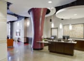 Thumbnail 41 of 50 - a lobby with a reception desk and a large red pillar
