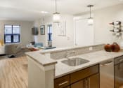 Thumbnail 31 of 50 - a kitchen with a sink and a view of a living room