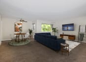 Thumbnail 2 of 15 - a living room with a blue couch and a table and chairs