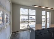 Thumbnail 24 of 37 - a view of a dining room with a large window and a table with black cabinets