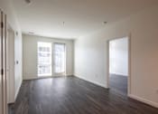 Thumbnail 12 of 37 - an empty living room with wood floors and white walls