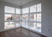 Thumbnail 22 of 37 - an empty living room with large windows and wood floors