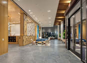 Thumbnail 8 of 37 - a large lobby with furniture and glass doors