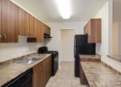 Thumbnail 10 of 23 - a kitchen with a black refrigerator freezer next to a stove top oven