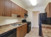 Thumbnail 1 of 23 - a kitchen with a stove a sink and a refrigerator