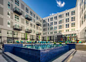 Thumbnail 1 of 37 - a large pool in front of a large apartment building