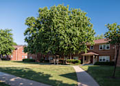 Thumbnail 14 of 14 - A tree in front of a brick building.