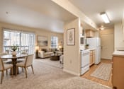 Thumbnail 3 of 17 - A well-lit, spacious kitchen and living room with modern furniture and appliances.