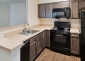 Thumbnail 6 of 12 - a model kitchen with black appliances at Clarendon Court Apartments