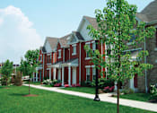 Thumbnail 2 of 5 - A red brick house with a white door and windows.