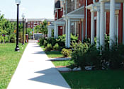 Thumbnail 3 of 5 - A long white pathway leads the eye through a grassy area and up a hill.