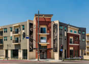Thumbnail 2 of 10 - a row of apartment buildings on a city street at Santa Cecilia Apartments