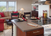 Thumbnail 4 of 6 - a living room with a kitchen and a couch at Valentine Apartments