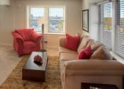 Thumbnail 3 of 6 - a living room with a couch and a table at Valentine Apartments