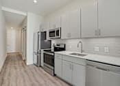 Thumbnail 37 of 40 - a white kitchen with stainless steel appliances and white cabinets at Sinclaire on Seminary, Alexandria, 22311