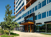 Thumbnail 5 of 40 - a building with a sidewalk and trees in front of it at Sinclaire on Seminary, Alexandria Virginia