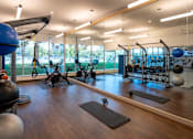 Thumbnail 12 of 40 - a gym with weights and other exercise equipment and a view of a tennis court at Sinclaire on Seminary, Alexandria, VA 22311
