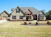 Thumbnail 18 of 24 - A house with a grey roof and a brown brick chimney.