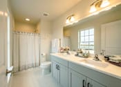 Thumbnail 19 of 20 - Primary bathroom with double vanity and toilet