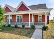 Thumbnail 5 of 23 - A red house with white trim and a porch.