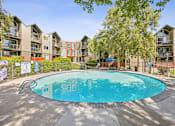 Thumbnail 13 of 36 - A round swimming pool in the middle of a courtyard surrounded by apartment buildings.