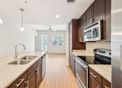Thumbnail 21 of 64 - A kitchen with wooden cabinets and a granite countertop. at The Dakota, Florida, 33458