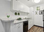 Thumbnail 18 of 57 - A kitchen with white cabinets and a black refrigerator. at Millennium at Creve Coeur, Missouri
