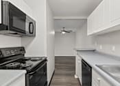 Thumbnail 14 of 57 - Kitchen with white cabinets and a black stove top oven at Creve Coeur, Creve Coeur, MO