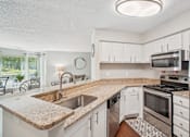 Thumbnail 4 of 43 - A kitchen with a granite countertop and stainless steel appliances. at University Ridge Apartments, North Carolina, 27707