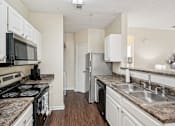Thumbnail 4 of 32 - A kitchen with a stove, microwave, refrigerator, and sink. at Cedar Springs Apartments, North Carolina