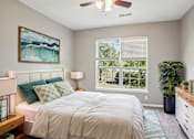 Thumbnail 6 of 31 - A bedroom with a bed, a ceiling fan, and a painting on the wall. at Bridford Lake Apartments, North Carolina, 27407