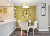 Thumbnail 8 of 41 - A kitchen with a table and chairs in front of a green wall.