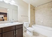 Thumbnail 30 of 64 - A bathroom with a white toilet, sink, and bathtub. at The Dakota, Jupiter, FL