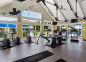 Thumbnail 9 of 20 - a gym with exercise equipment and windows with a pool in the background at Brookstone Village, Cincinnati