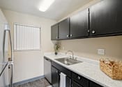 Thumbnail 6 of 35 - A kitchen with black cabinets and a white sink. at Broadmoor Springs, Colorado Springs