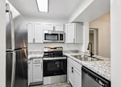 Thumbnail 7 of 55 - A kitchen with a refrigerator, microwave, oven, and sink. at Lakeside Glen Apartments, Melbourne, FL