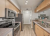 Thumbnail 13 of 117 - A kitchen with a stove, microwave, refrigerator, and sink. at Heritage Bay, Jensen Beach