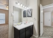 Thumbnail 17 of 27 - A bathroom with a sink, mirror, and lighting fixture.