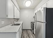 Thumbnail 23 of 45 - A kitchen with a black refrigerator and white cabinets at Spyglass Creek, Denver, 80224