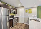 Thumbnail 9 of 41 - A kitchen with a stainless steel refrigerator, oven, and microwave.